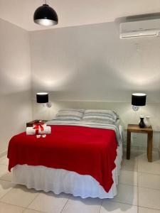 a bedroom with a large bed with a red blanket at Pousada 3 Bacias Penedo in Penedo