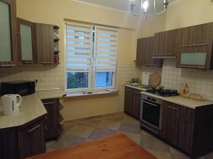 a kitchen with wooden cabinets and a stove and a window at Hostel Tet6 in Gdynia +9 photos