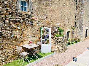 a table and chairs in front of a stone building at La Parenthèse in Vitreux