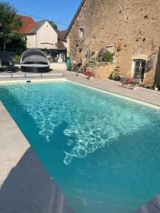 a swimming pool with blue water in front of a house at La Parenthèse in Vitreux
