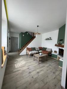 a living room with a couch and a staircase at La Parenthèse in Vitreux