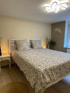 a bedroom with a bed with a white comforter and pillows at La Parenthèse in Vitreux +41 photos