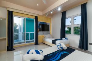a bedroom with a bed and a large window at Ocean Bounty in Ukulhas