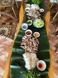 a long table of food on a banana leaf at Nhà Bên Suối Retreat in Làng Tè