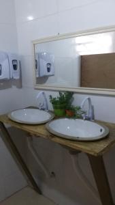 uma casa de banho com 2 lavatórios e um espelho em Vibe House Hostel em Florianópolis