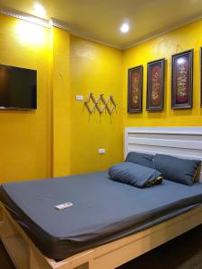 a bed in a room with a yellow wall at Nhà Bên Suối Retreat in Làng Tè