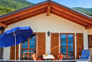 ein Haus mit einem blauen Sonnenschirm auf einer Terrasse in der Unterkunft Case Bellissime in Tronzano Lago Maggiore