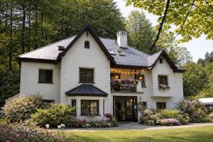 a white house with flowers in the front yard at Rezidence - HAMR in Nové Hrady