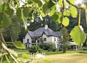 a large white house with a black roof at Rezidence - HAMR in Nové Hrady