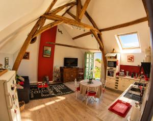 a kitchen and living room with wooden beams at La Closeraie in Noyers-sur-Cher