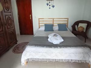 a bedroom with a bed with a towel on it at Minha Alegre Casinha in Sines