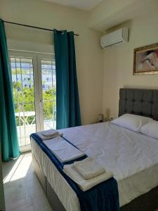 a bedroom with a bed with blue curtains and a window at Mirkashouse in Limenas