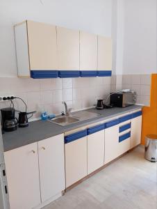 a kitchen with white cabinets and a sink at Mirkashouse in Limenas
