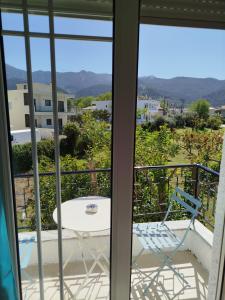 a room with a table and a chair on a balcony at Mirkashouse in Limenas