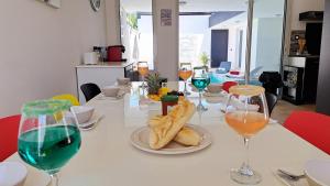 a table with glasses of wine and bread on it at Azot Villa in Le Tampon