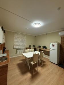 a kitchen with a table and a white refrigerator at Duman House in Almaty
