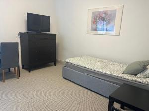 a bedroom with a bed and a dresser with a television at Raasiku majutus in Raasiku