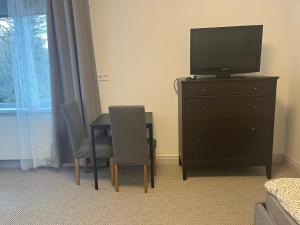a bedroom with a tv and a table and chairs at Raasiku majutus in Raasiku