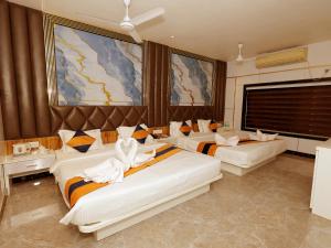 a hotel room with two beds and a large window at N S International in Kolkata
