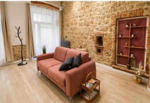 a living room with a brown couch and a brick wall at La Casina del Corso in Massa Marittima