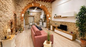 a living room with a red couch and a brick wall at La Casina del Corso in Massa Marittima
