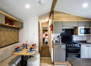 a kitchen with a table and a stove and a counter at 26 Ocean View in Llwyngwril