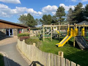 a playground with a yellow slide and swings at 26 Ocean View in Llwyngwril