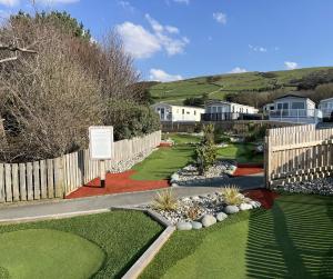 a garden with a fence and a yard with grass at 26 Ocean View in Llwyngwril +18 photos