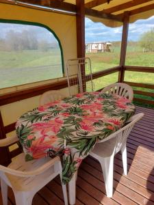 a table and two chairs on a porch with a table and a tablecloth at Au refuge de Lahontan in Castelnau-dʼAuzan