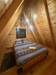 a bed in the middle of a room in a log cabin at Black Pine Chalet in Meždo