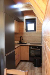 a kitchen with a stainless steel refrigerator and a sink at Black Pine Chalet in Meždo