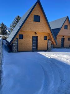 a large wooden barn in the snow at Black Pine Chalet in Meždo