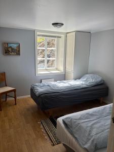 a bedroom with two beds and a window at Strand huset in Hitra