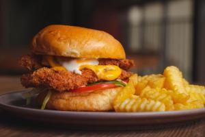 a chicken sandwich and french fries on a plate at Viajero Lima - Barranco Hostel in Lima