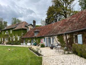 an old house with ivy on the side of it at La Roseraie de Malpas in Quingey