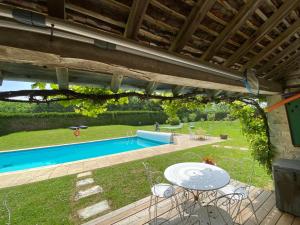 a patio with a table and chairs and a pool at La Roseraie de Malpas in Quingey