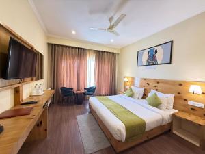 a hotel room with a bed and a flat screen tv at Crown Himalaya in Leh
