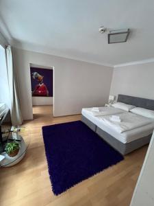 a bedroom with a large bed and a blue rug at Urban City Nest in Vienna
