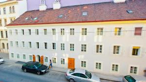 a large white building with cars parked in front of it at Urban City Nest in Vienna