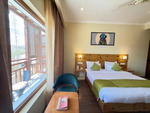 a hotel room with a bed and a balcony at Crown Himalaya in Leh +29 photos