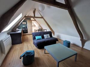 a living room with a couch and a table at Gîtes Chambres d'hôtes de charme B&B - La Cense du Pont - Campagne de Lille in Bachy