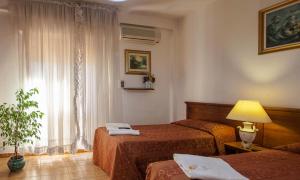 a hotel room with two beds and a lamp at Hotel Garden in Nuraminis +20 photos