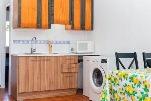 a kitchen with a sink and a washing machine at Bon repós B5 in Cala en Bosc
