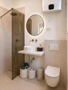 a bathroom with a sink and a toilet and a mirror at NAIA apartment in Koper