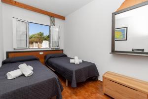 a bedroom with two beds and a mirror at Bon repós B5 in Cala en Bosc +18 photos