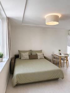 a bedroom with a bed and a table in a room at NAIA apartment in Koper