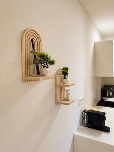 a kitchen with two wooden shelves with potted plants at NAIA apartment in Koper