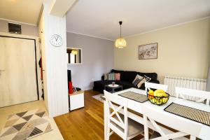 a kitchen and living room with a table and a couch at BellaVita Apartman in Vrnjačka Banja
