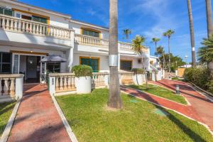 a house with a palm tree in front of it at Bon repós B5 in Cala en Bosc