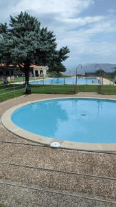 a large blue swimming pool with a tree in the background at Apartamento rural Rubí in El Torno